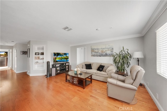 living room with crown molding, light hardwood / wood-style floors, and plenty of natural light