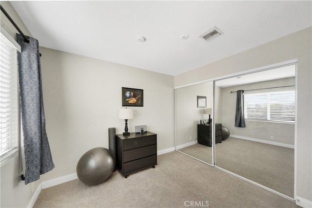 bedroom featuring light carpet and a closet