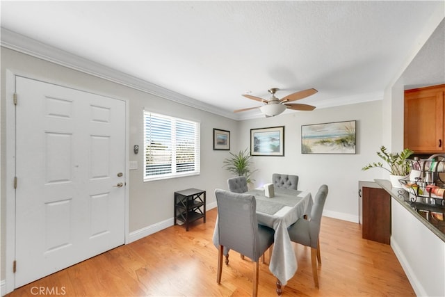 dining area with ceiling fan, crown molding, and light hardwood / wood-style floors