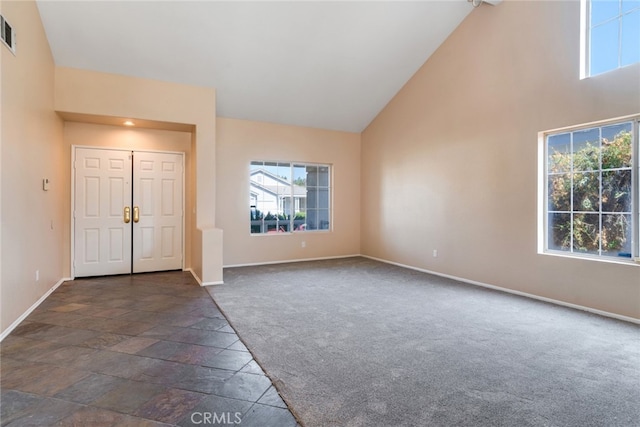 carpeted entrance foyer with high vaulted ceiling