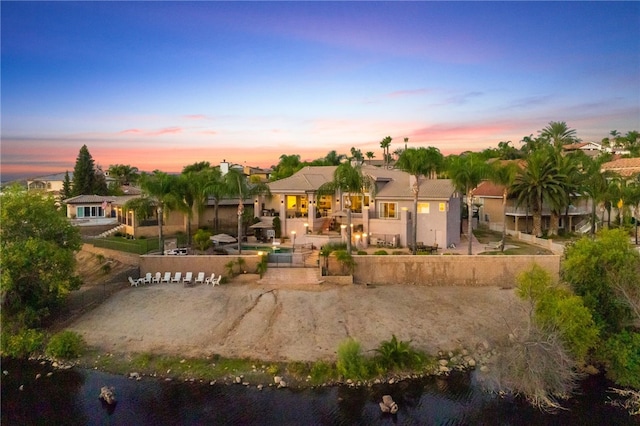 back house at dusk with a water view