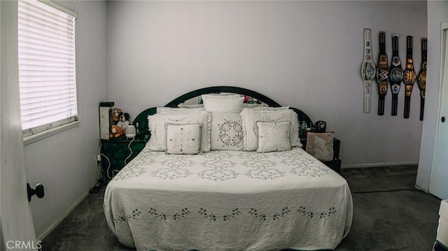 bedroom featuring baseboards and dark colored carpet