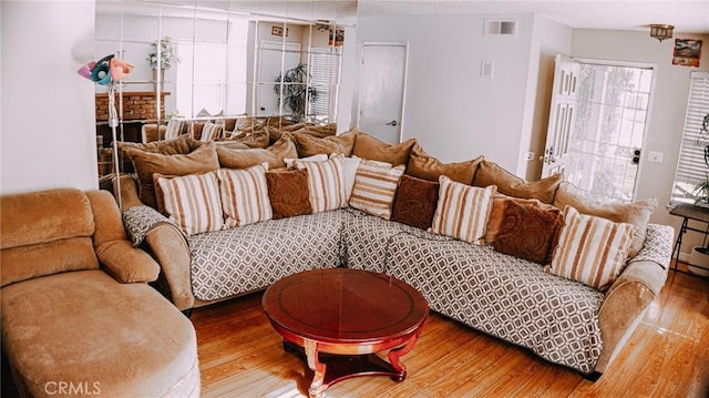 living area with visible vents and wood finished floors