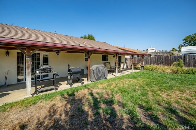 back of house with a patio and a yard