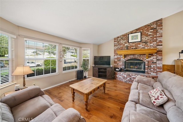 living room with vaulted ceiling, a fireplace, and hardwood / wood-style floors