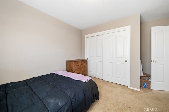 bedroom featuring light colored carpet and a closet