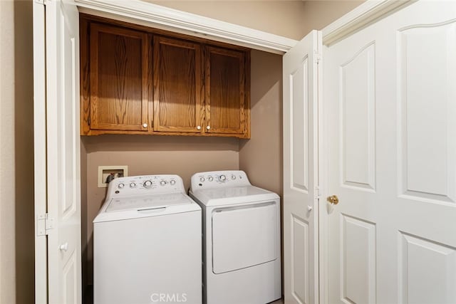 laundry area featuring washer and clothes dryer and cabinets