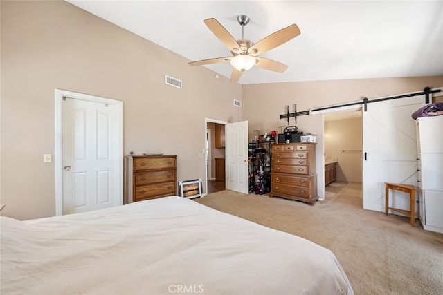 bedroom featuring ceiling fan, connected bathroom, high vaulted ceiling, light colored carpet, and a barn door