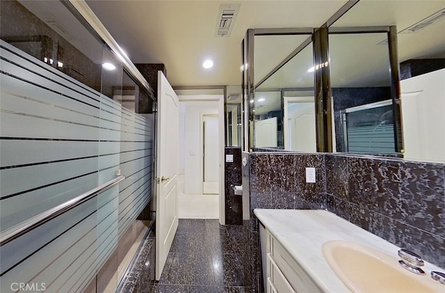 bathroom featuring tasteful backsplash, vanity, and tile walls