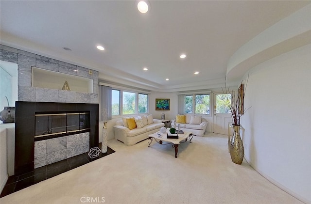 living room featuring a fireplace and dark carpet