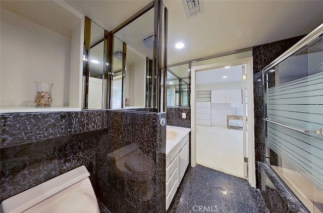 bathroom with vanity, tile walls, and an enclosed shower