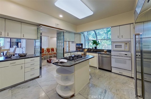 kitchen featuring built in appliances, sink, and a kitchen island