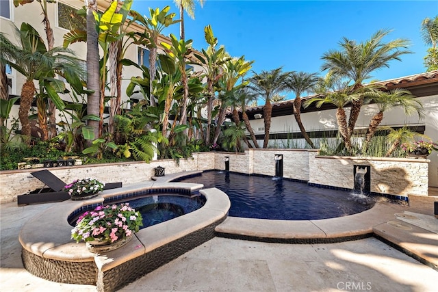 view of pool featuring pool water feature and an in ground hot tub