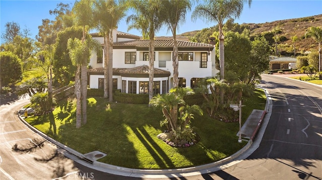 mediterranean / spanish-style home featuring a front lawn