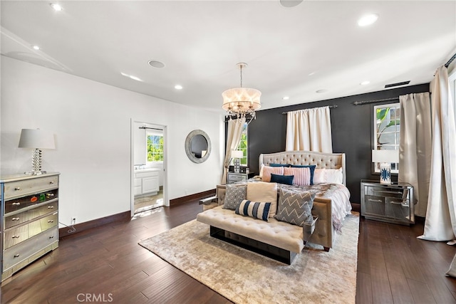 bedroom featuring a chandelier, ensuite bathroom, and dark wood-type flooring