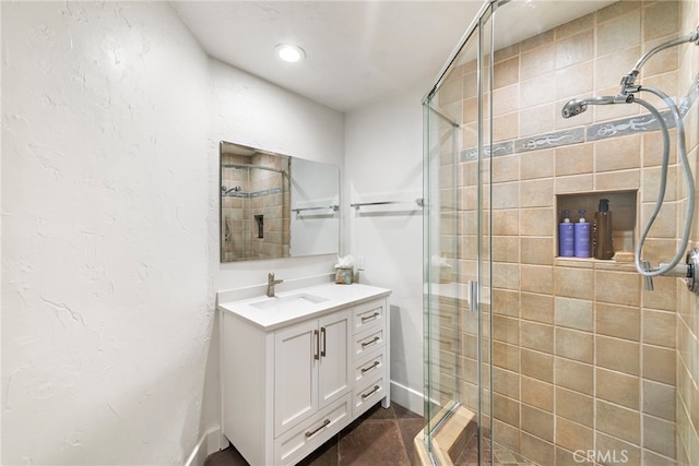 bathroom with a shower with door and vanity