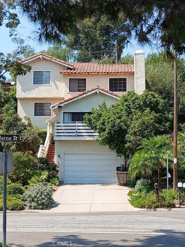 mediterranean / spanish home featuring a balcony and a garage