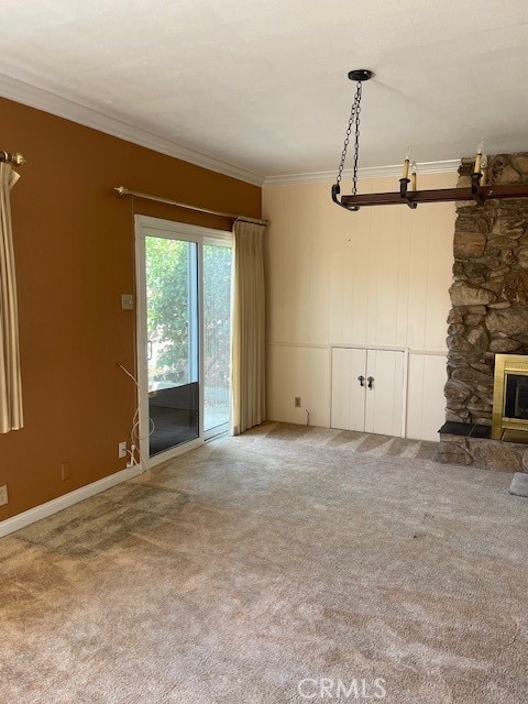 unfurnished living room with a stone fireplace, carpet flooring, and ornamental molding