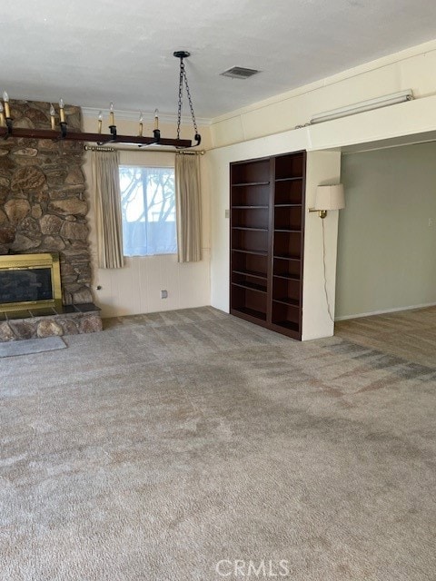 unfurnished living room featuring a fireplace, ornamental molding, and carpet