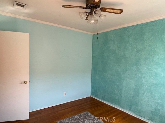 empty room with ceiling fan, dark hardwood / wood-style floors, and crown molding