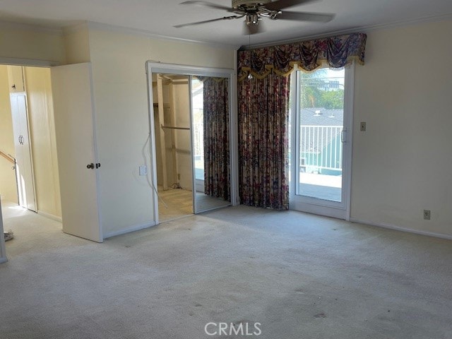 spare room with ornamental molding, ceiling fan, and light colored carpet