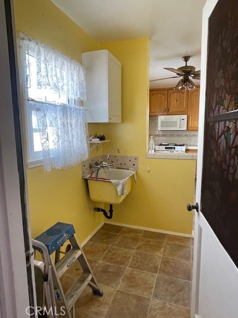 bathroom with decorative backsplash, ceiling fan, and sink