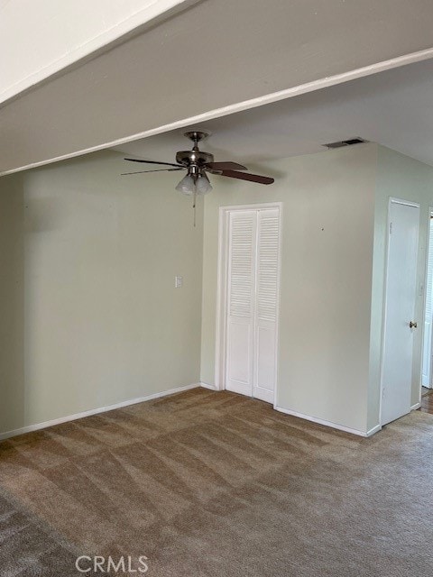 carpeted spare room featuring ceiling fan