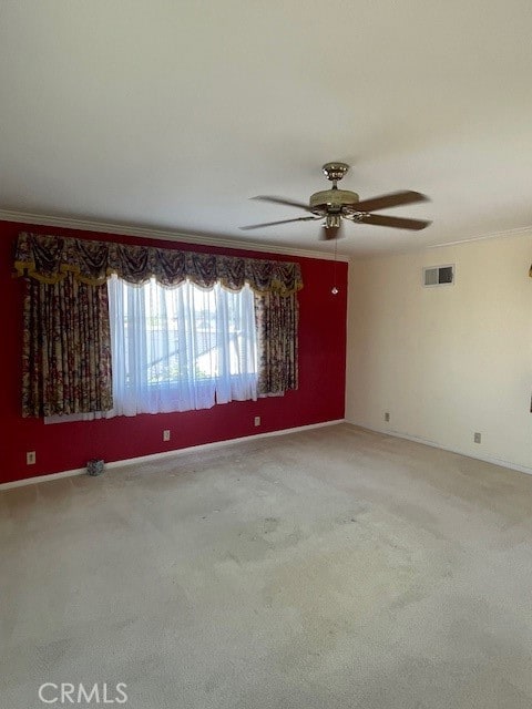 unfurnished room with ceiling fan, carpet flooring, and crown molding