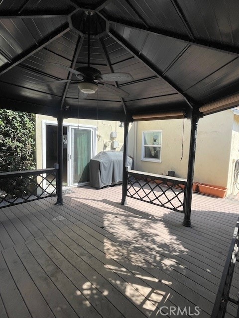 wooden terrace featuring ceiling fan and area for grilling