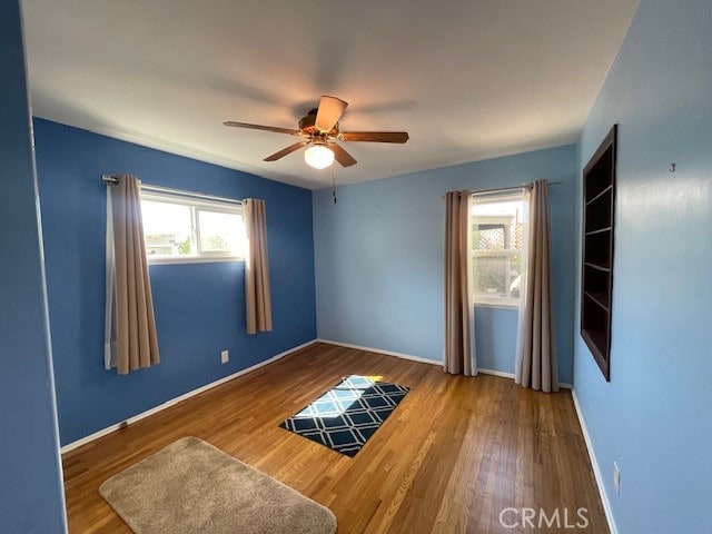 spare room with ceiling fan and hardwood / wood-style floors