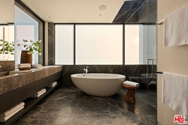 bathroom with independent shower and bath, floor to ceiling windows, and vanity