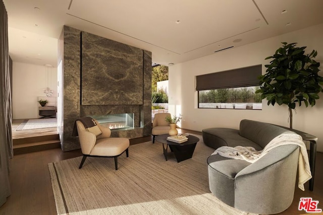 sitting room featuring a high end fireplace and wood-type flooring