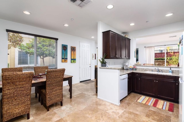 kitchen featuring a healthy amount of sunlight, sink, white dishwasher, and light stone counters