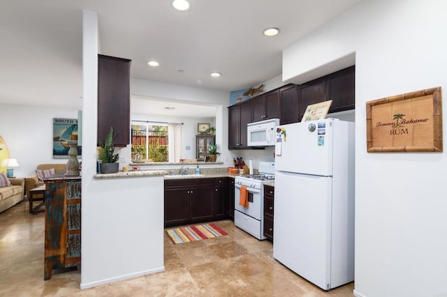 kitchen with light stone countertops, white appliances, dark brown cabinetry, and sink