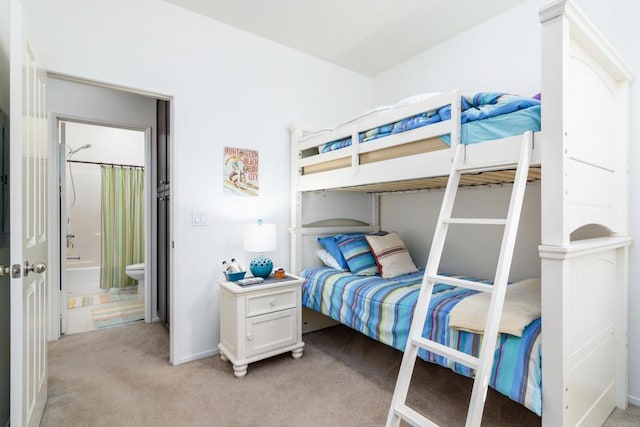 bedroom featuring connected bathroom and light colored carpet