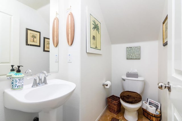 bathroom featuring vaulted ceiling, sink, and toilet