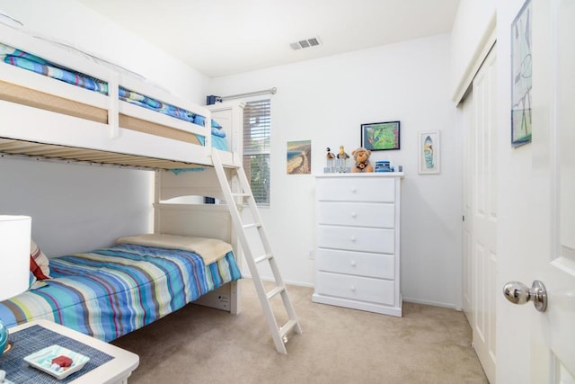 bedroom with light colored carpet and a closet