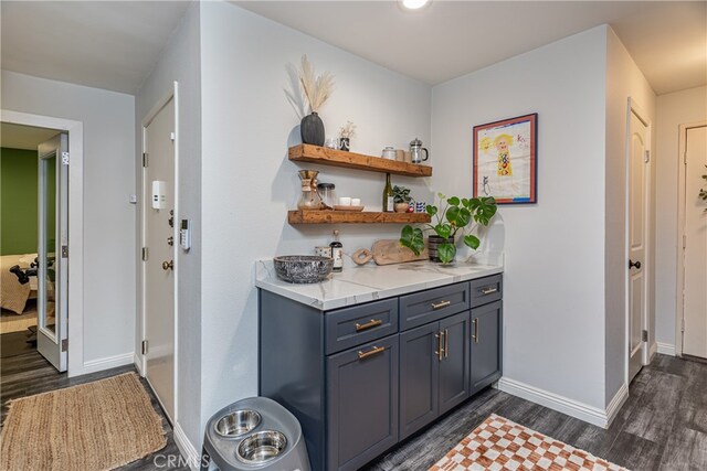 bar featuring dark wood-type flooring and gray cabinets