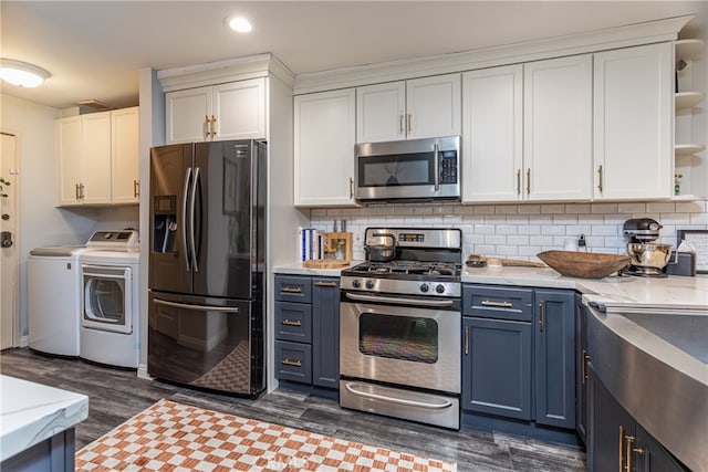 kitchen featuring washer and clothes dryer, white cabinets, appliances with stainless steel finishes, and blue cabinets