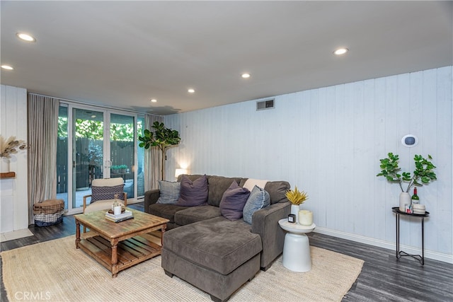 living room with wood-type flooring and wood walls