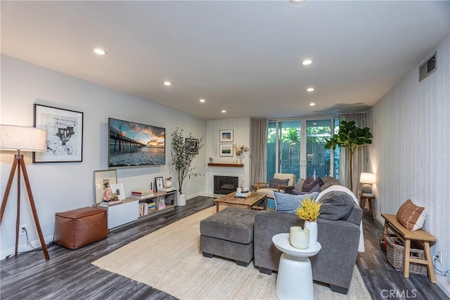 living room featuring baseboards, visible vents, wood finished floors, a fireplace, and recessed lighting