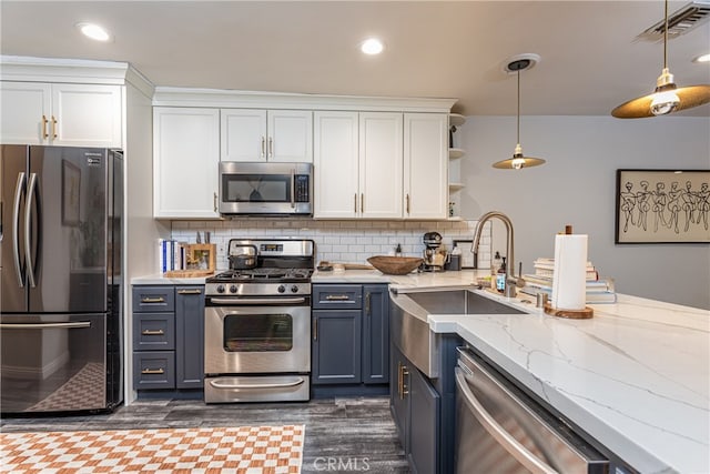 kitchen with white cabinets, hanging light fixtures, tasteful backsplash, stainless steel appliances, and dark hardwood / wood-style floors