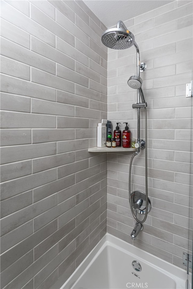 bathroom featuring tiled shower / bath