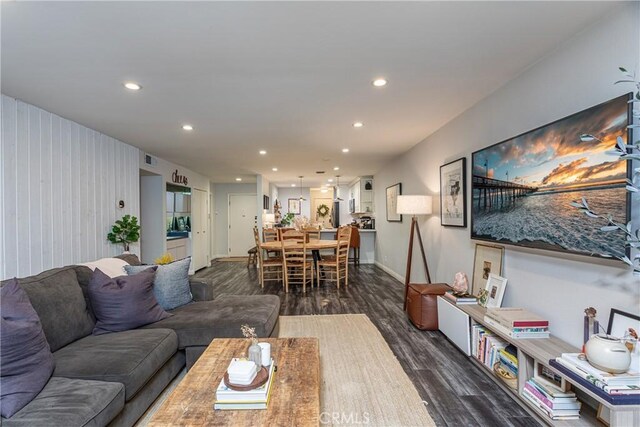 living room with dark hardwood / wood-style floors and wood walls