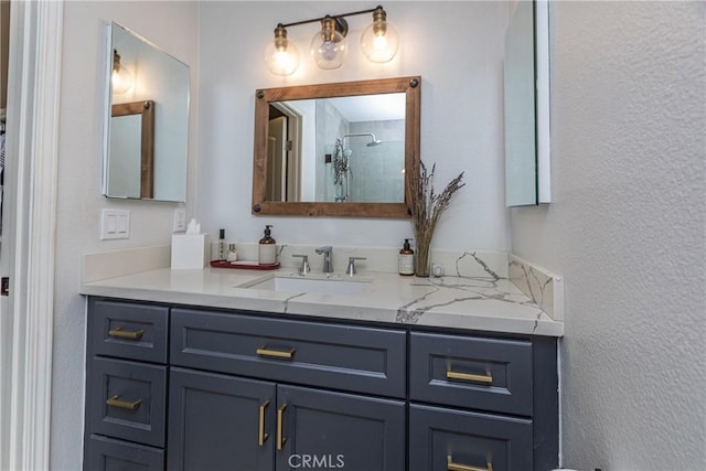 bathroom featuring a textured wall, a shower stall, and vanity