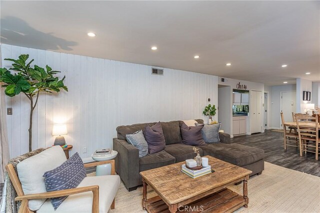 living room featuring wooden walls and hardwood / wood-style flooring