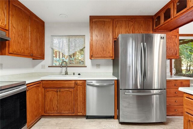 kitchen with brown cabinets, appliances with stainless steel finishes, and a sink