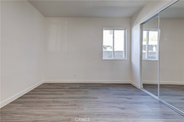 unfurnished bedroom with wood-type flooring and a closet