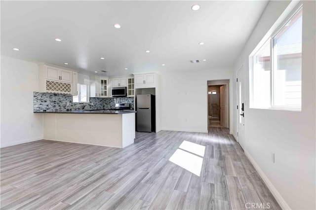 8812 Laurel Canyon Blvd, Sun Valley, CA 91352 - kitchen with appliances with stainless steel finishes, dark countertops, a peninsula, open floor plan, and white cabinetry