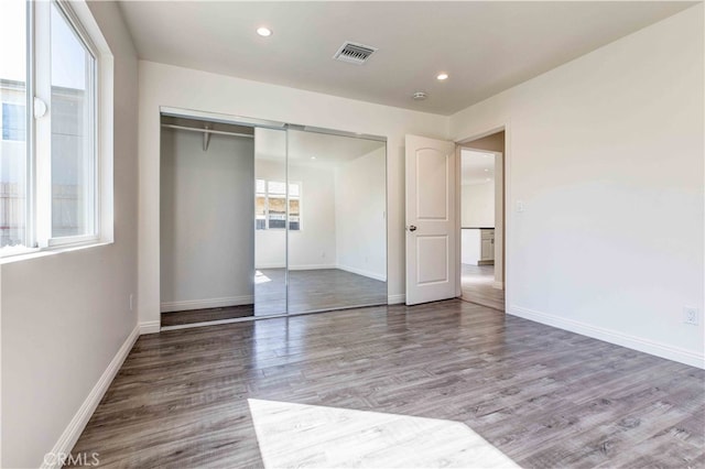 unfurnished bedroom with wood-type flooring and a closet